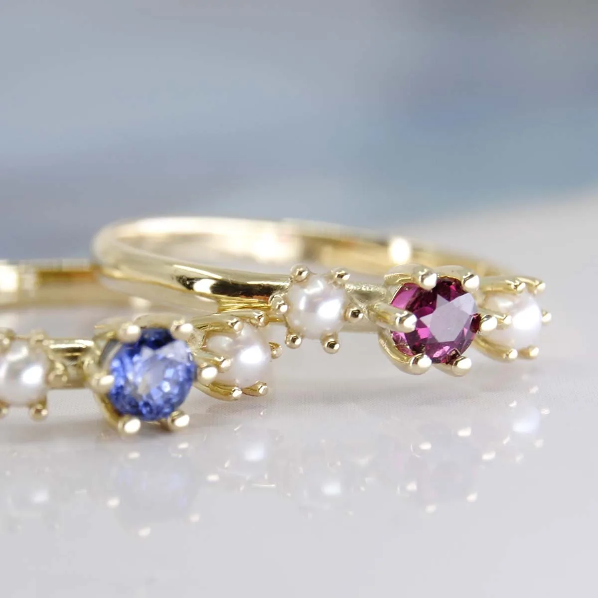 Geelgouden ring Rome met Saffier en parel en Geelgouden ring bogota met Robijn en Parel